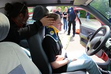 Einer verletzten Person in einem verunfallten Auto wird eine HWS-Distraktionsschiene zur Stabilisierung angelegt. Dabei handelt es sich um eine Übung.